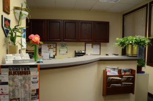 The front receptionist desk for Donahue & Associates LLC with flowers and notes placed everywhere in Grafton, WI.